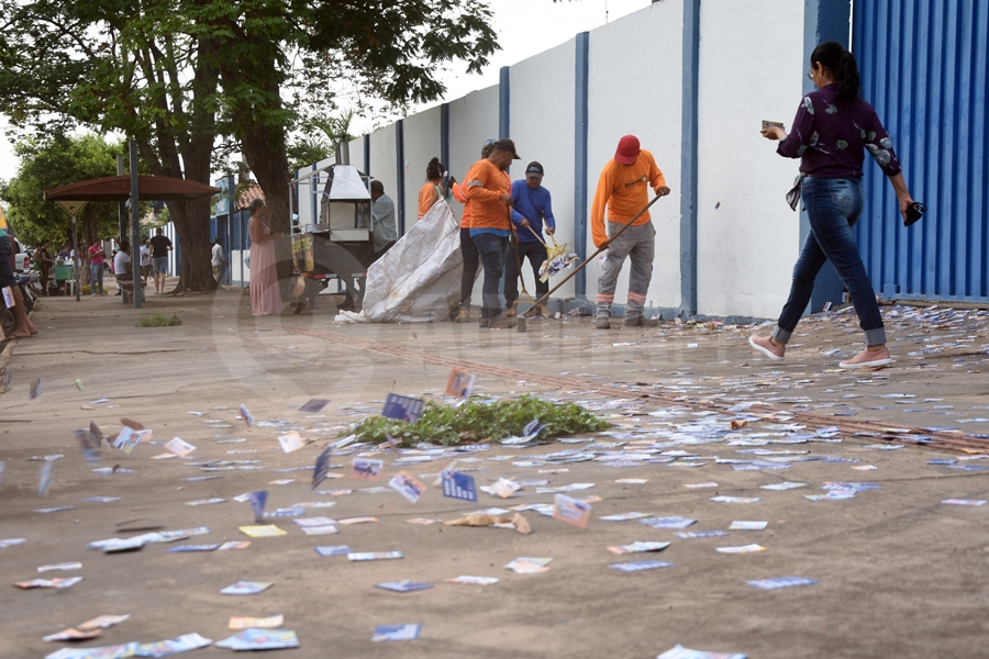 Imagem: Santinhos sendo recolhido em porta de escola 'Mar de santinhos' invade ruas de Rondonópolis